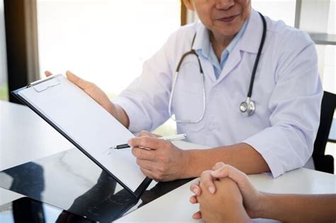 Premium Photo Midsection Of Doctor Writing On Paper