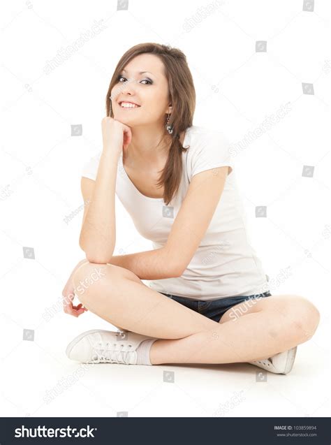 Happy Teenage Girl Sitting On The Floor With Crossed Legs Full Length