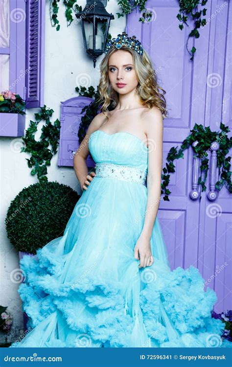 Young Beautiful Woman With Long Blond Hair In Elegant Dark Blue Dress