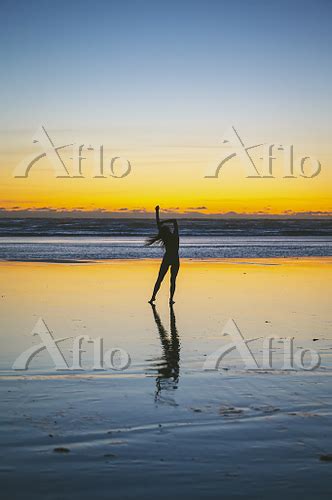 Naked female posing on the beach at sunset 写真素材ストックフォトのアフロ
