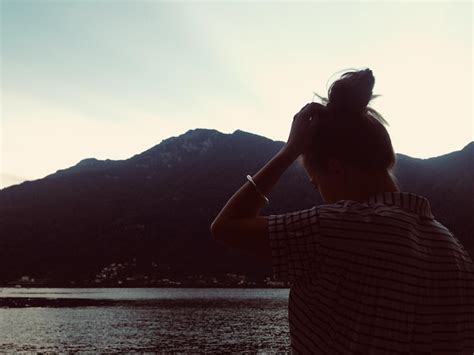 Premium Photo Rear View Of Woman Standing At Lakeshore Against Sky During Sunset