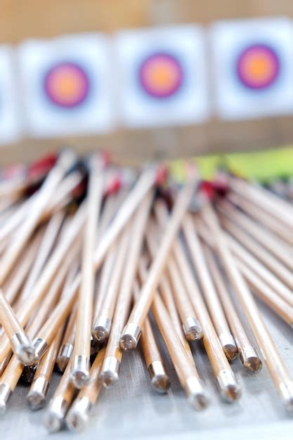 Premium Photo | Close-up of arrows on table against archery targets