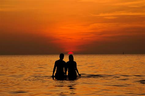 Silhouette of couple in the sea at sunset 30534616 Stock Photo at Vecteezy