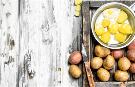 Premium Photo Peeled Potatoes In A Saucepan With Unpeeled Potatoes On