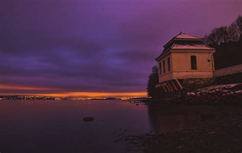 White And Brown Concrete Building Near Body Of Water During Night Time Photo Free Sky Image On