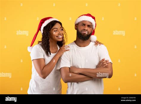 Happy African American Woman In Santa Hat Comforting Her Upset Husband