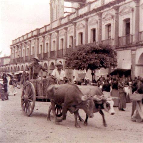 An Old Black And White Photo Of People Riding In A Cart Being Pulled By