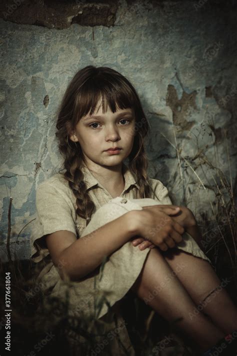 sad teenage girl sitting by an abandoned building Stock Photo | Adobe Stock