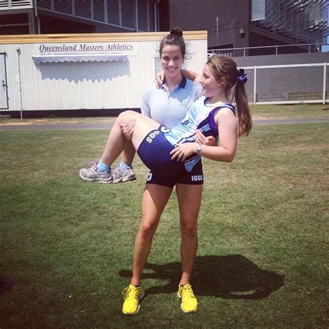 Two Women Are Posing For A Photo In The Grass With Their Arms Around