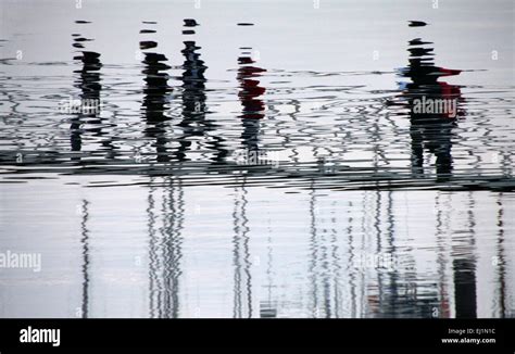 View Of Reflection Of People Distorted On The Water On The Docks Stock