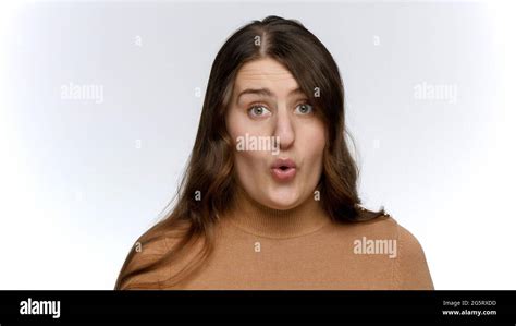 Studio Portrait Of Amazed Woman Opens Widely Eyes And Mouth Shock And