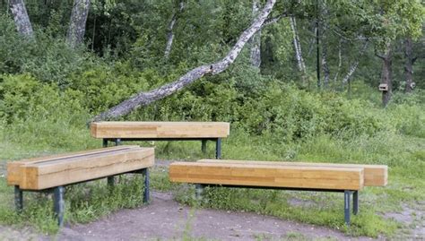 Three Wooden Benches Sitting On Top Of A Grass Covered Field Next To