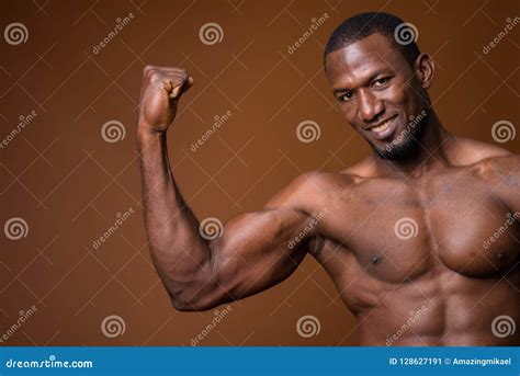 Handsome Muscular African Man Shirtless Against Brown Background Stock