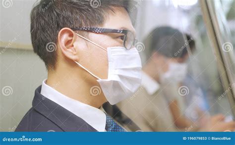 Young Man Wearing Face Mask Travels On Crowded Subway Train Stock Image