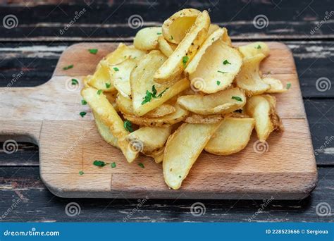 Patatas Fritas Cortadas Con Hierbas En Un Tablero De Cocina De Madera