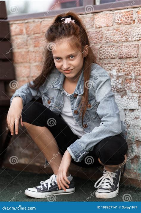 Portrait Of A Beautiful Teenage Girl Posing Against A Brick Wall Stock