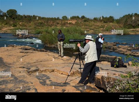 Tourists Photographing On The River Bank Of The Sabie River In The Sabi