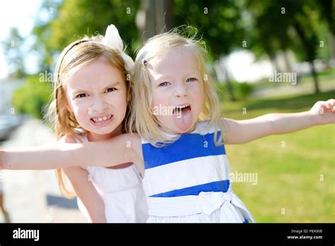 Two Little Sisters Making Funny Faces Outdoors Stock Photo Alamy