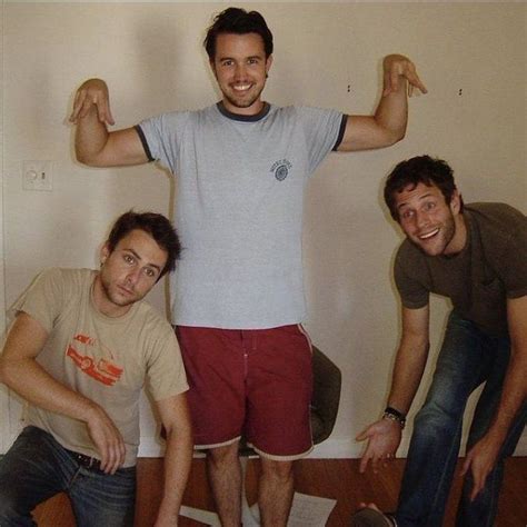 Three Men Posing For The Camera With Their Arms In The Air