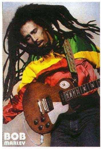 A Man With Dreadlocks Holding A Guitar