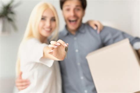 premium photo couple showing  house keys hugging indoor shallow depth