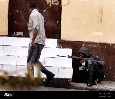 A Haitian Police Officer Takes Cover Next To Haitis National Palace After Gunfire Erupted From