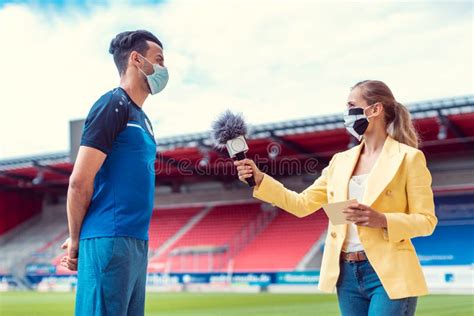 Reporter Doing Interview With Football Player During Covid 19 Stock