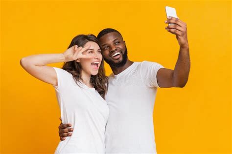 Cheerful Interracial Couple Taking Selfie With Smartphone Having Fun Together Stock Image