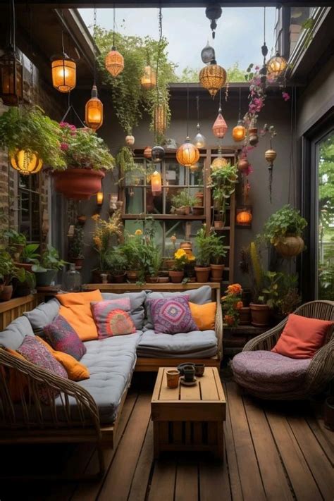 An Outdoor Living Room With Lots Of Plants And Lights Hanging From The