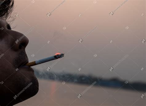 Man Smoking A Cigarette On A Sunset Background Cigarette Addiction