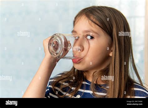 A Little Girl Drinks Water From A Glass Cup Little Girl Holding A