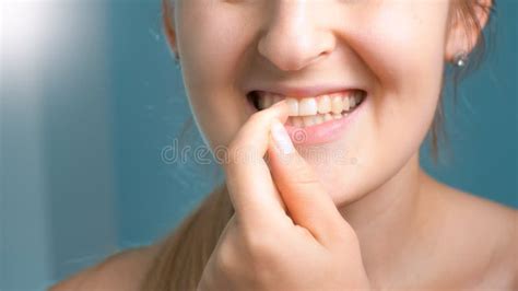 Closeup Image Of Young Woman Taking Out Stuck Food From Teeth Stock