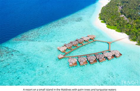 A Boardwalk Pathway Over Shallow Turquoise Water Leading To A Resort In