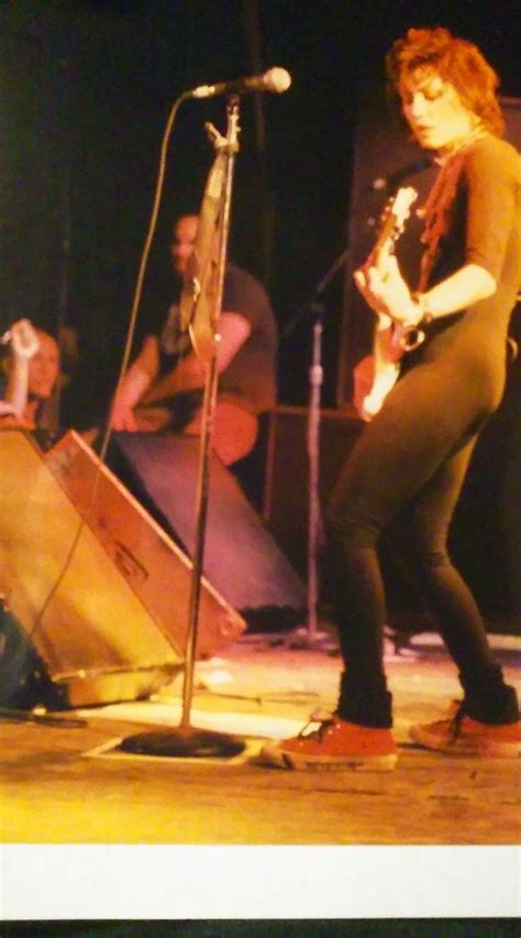 A Woman Standing In Front Of A Microphone On Stage With An Electric