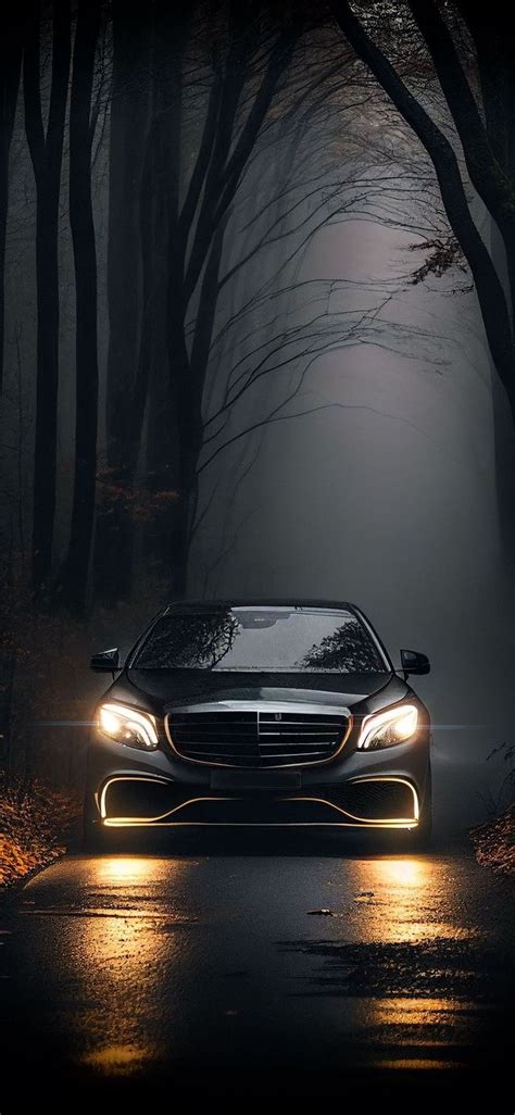 A Car Driving Down The Road At Night With Its Headlights On And Foggy