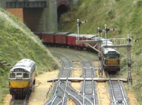 two trains passing each other on tracks in a model train track set with ...