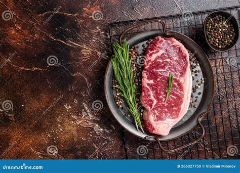 Raw New York Or Striploin Beef Meat Steak With Rosemary And Pepper