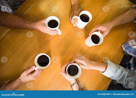 Manos Que Sostienen Las Tazas De Caf En La Tabla Imagen De Archivo