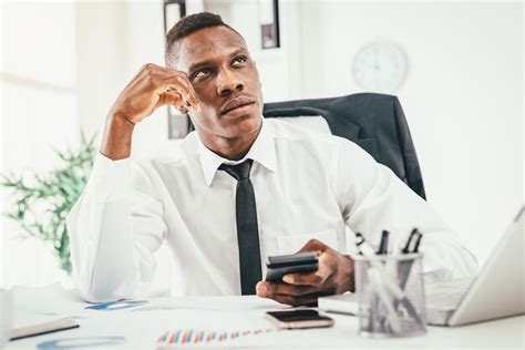 Premium Photo Pensive African Businessman Working On Calculator In