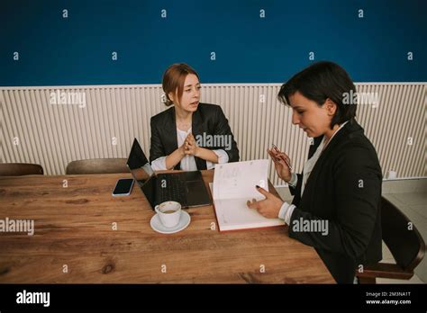 Brunette Business Girl Looking Trough The Notes While Talking With Her Colleague At The Office
