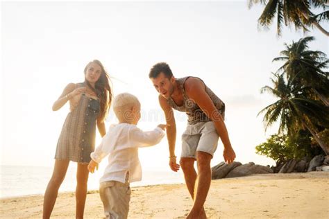 Feliz Familia En La Isla Tropical Al Atardecer Jugando Con Su Hijo Foto