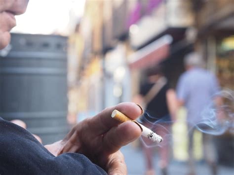 Imagem recortada de mão de homem segurando um cigarro Foto Premium