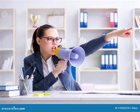 Angry Businesswoman Yelling With Loudspeaker In Office Stock Photo