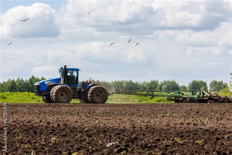 Blue New Holland Tractor With Double Wheels Pulling Disc Harrow With