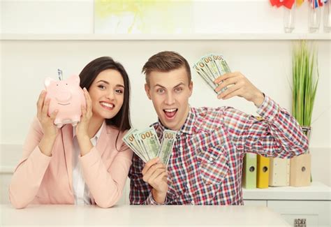 Feliz pareja joven con billetes de dólar y alcancía concepto de ahorro