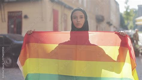 Portrait Of Beautiful Young Muslim Woman Wearing Hijab Headscarf With Lgbt Flag Standing On The