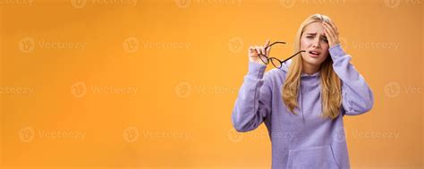 Upset gloomy bothered blond girl take-off glasses cringing grimacing