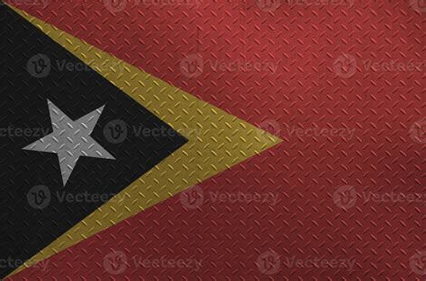 Timor Leste flag depicted in paint colors on old brushed metal plate or wall closeup. Textured ...