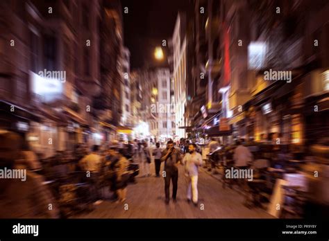 Blurry motion image of people walking on a street in Taksim /Beyoglu area at night in Istanbul ...