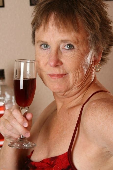 Old Granny With Big Tits Sandra D Doffs Her Red Dress And Poses Nude